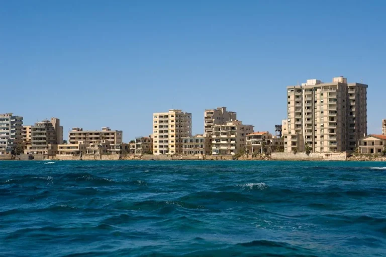 Explore the mysterious story of Varosha, Famagusta’s ghost town — once a luxury resort, now a window into Cyprus’s divided history. Famagusta’s Ghost Town (Varosha): What You Need to Know Once the crown jewel of Cyprus’s tourism industry, Varosha in Famagusta now stands as one of the most hauntingly beautiful places on the island. Known as the “Ghost Town of Cyprus,” it tells a story of lost glamour, frozen time, and political division — making it a must-visit for anyone interested in the island’s history and identity. 1. The Glamorous Past Before 1974, Varosha was one of the Mediterranean’s most famous resorts. Celebrities like Elizabeth Taylor, Brigitte Bardot, and Richard Burton vacationed there. Its coastline was lined with luxury hotels, cafés, and boutiques — a symbol of Cyprus’s golden age of tourism. But that all changed in the summer of 1974, when the area was abandoned overnight during the conflict that divided Cyprus. Since then, time has stood still within its crumbling buildings and silent streets. 2. What Happened in 1974 After the events of 1974, Varosha was fenced off and left uninhabited for nearly five decades. The area became part of the military zone controlled by the Turkish forces, completely closed to the public. Nature slowly began to reclaim the city — trees grew through hotel lobbies, cars rusted in the streets, and shop windows froze in the past. 3. Reopening to Visitors In 2020, parts of Varosha were reopened to the public for the first time in nearly 50 years. Visitors can now walk or cycle through certain areas of the district, including parts of Democracy Street and the Glossa Beach area. Although entry to some buildings is still restricted, the reopened zone offers a rare and powerful glimpse into a living museum of history. 💡 Tip: Bring water and comfortable shoes — much of the area is only accessible by foot or bike, and the sun can be intense. 4. What You’ll See Today Visiting Varosha is like stepping back in time. You’ll find: Empty hotels with broken balconies and faded signs Overgrown gardens and cars frozen in the 1970s Glossa Beach, now open for swimming with lifeguards and facilities Informational panels explaining the area’s history and context Photography is generally allowed, but visitors are expected to respect all restricted zones and signs. 5. Why It Matters Varosha is more than a tourist site — it’s a symbol of Cyprus’s divided history and a reminder of the importance of peace and coexistence. For students and visitors alike, it’s a place to reflect on how conflict shapes communities and memories. 6. How to Visit Varosha is located on the southeastern coast of Cyprus, near Famagusta (Gazimağusa). Entry is currently free, and the area is open daily, though hours may vary by season. 💡 Tip: Combine your visit with nearby attractions such as the Othello Castle, Lala Mustafa Pasha Mosque, and the Famagusta Old Town walls — all within a short drive. A Walk Through Time Exploring Famagusta’s Ghost Town is an unforgettable experience — both eerie and deeply moving. It’s a rare chance to see history preserved in silence, where every building tells a story of hope, loss, and resilience.